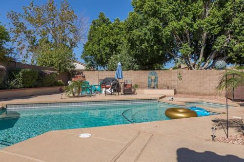 a swimming pool with a table and a umbrella at Private paradise with pool heater, spa, billiards in Avondale