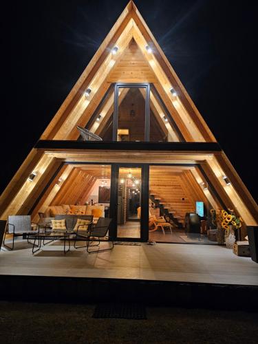 a house with a triangular roof with a living room at Sunflower House Radoinja in Nova Varoš