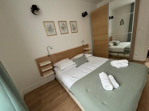 a bedroom with a bed with two towels on it at L'écrin à la Parisienne in Clichy