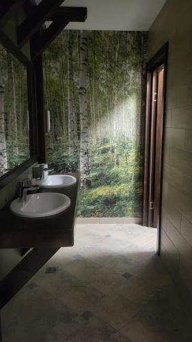 a bathroom with a sink and a wall with trees at Hanul BRĂTEANU in Suceava