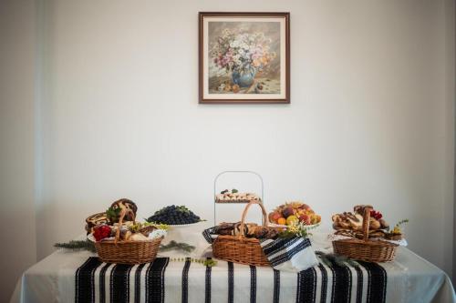 a table with baskets of fruits and vegetables on it at Hanul BRĂTEANU in Suceava