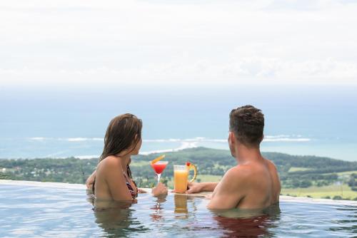 a man and a woman sitting in a swimming pool at Vista Celestial in Uvita
