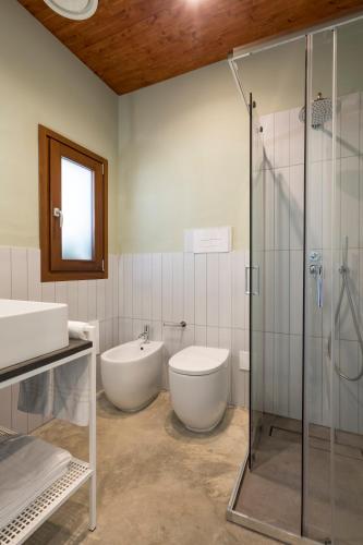 a bathroom with a toilet and a sink and a shower at LELE' Guesthouse in Scoglitti