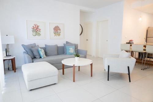 a living room with a couch and a table and chairs at Ka' Romana Residences in El Soco