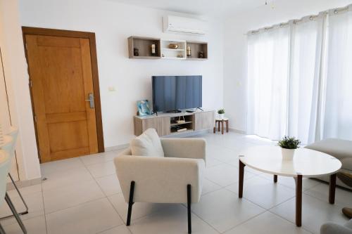 a living room with a couch and a table and a television at Ka' Romana Residences in El Soco