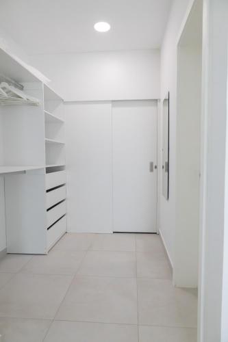 a white hallway with white cabinets and a door at Ka' Romana Residences in El Soco