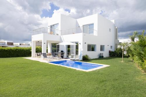 a white house with a swimming pool in the yard at Ka' Romana Residences in El Soco