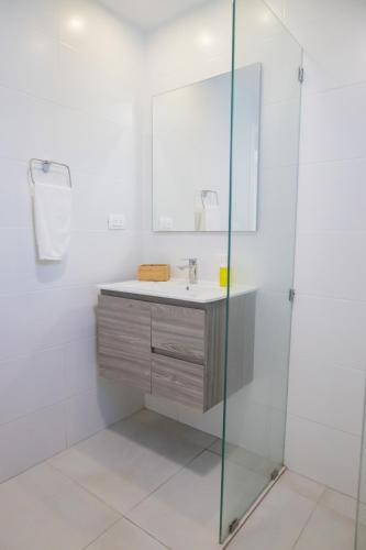 a bathroom with a sink and a shower at Ka' Romana Residences in El Soco