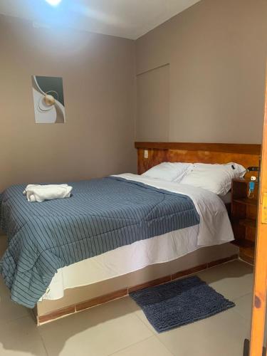 a bedroom with a bed with a blue comforter at Pousada Sitio Roda D'Água Mairinque in Mairinque