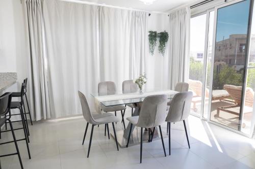 a dining room with a white table and chairs at Ka' Romana Residences in El Soco