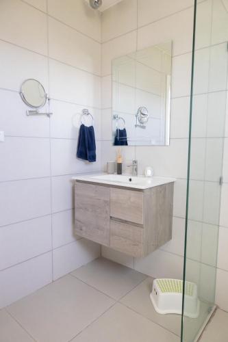 a bathroom with a sink and a mirror at Ka' Romana Residences in El Soco