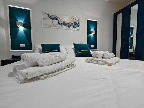 a large white bed with towels on top of it at Profumo di casa in Lascari