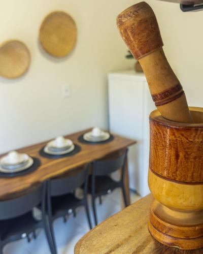 a wooden mortar and pestle sitting on top of a table at Flat 01 · Flats Japaratinga1- 200m da praia cozinha completa in Japaratinga