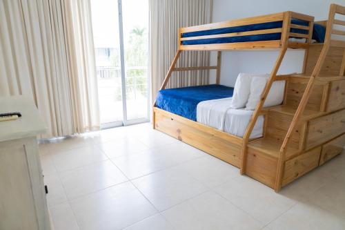a bedroom with a bunk bed and a large window at Ka' Romana Residences in El Soco