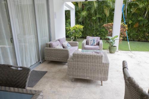 two wicker chairs and a table on a porch at Ka' Romana Residences in El Soco