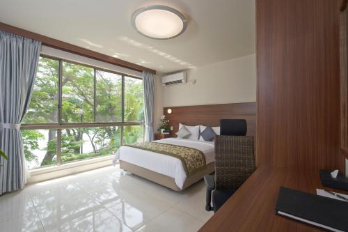 a bedroom with a bed and a large window at Axia South Cikarang Service Apartment in Cikarang