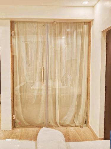 a sliding glass door with a shower in a bedroom at Baga Beach Way in Baga