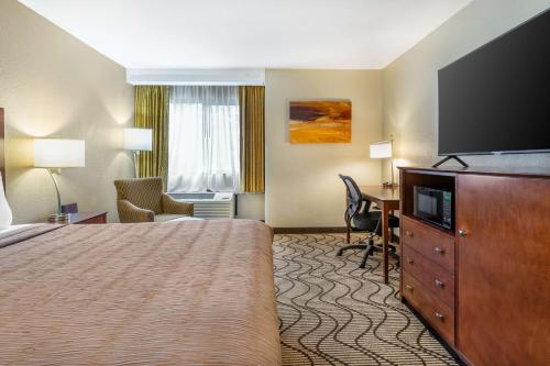 a hotel room with a bed and a flat screen tv at Best Western John Muir Inn in Martinez