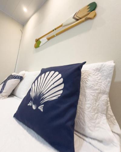a bed with a pillow and a baseball bat on a wall at Flats Japaratinga - a 200m da praia com varanda in Japaratinga