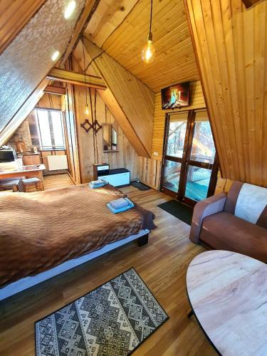 a bedroom with a bed and a couch in a room at Lavanda cottage in Verkhovyna