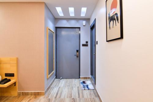 a hallway with a blue door in a building at Super Townhouse OAK Sayhallo Ecstasy in Bhubaneshwar