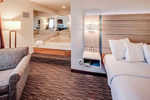 a hotel room with a bed and a bath tub at Best Western Port Columbus in Columbus