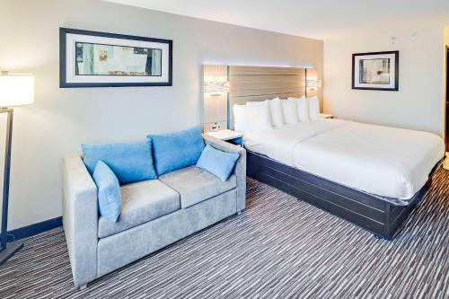 a hotel room with a bed and a couch at Best Western Port Columbus in Columbus