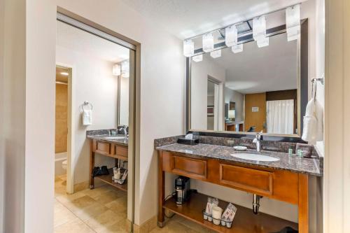 a bathroom with two sinks and a large mirror at Best Western Cotton Tree Inn in Rawlins