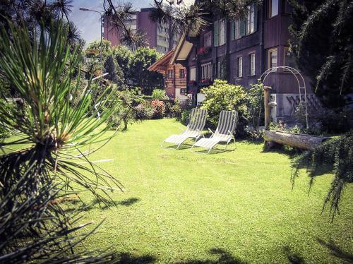 two chairs sitting in the yard of a house at Alpina Hotel in Interlaken
