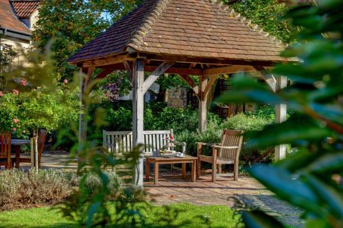 a wooden gazebo with a table and chairs at Best Western Plus Angel Hotel in Chippenham