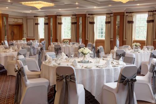 a banquet hall with white tables and chairs at Manor Hotel Solihull, BW Signature Collection in Bickenhill