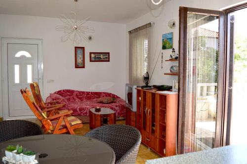 a living room with a table and chairs and a dining room at Apartment Ela in Rogač