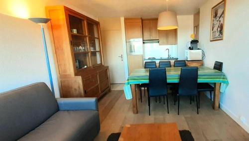 un salon avec une table et des chaises et une cuisine dans l'établissement Résidence Le Mustag - Résidence LE MUSTAG N°034 MAE-1441, à La Plagne Tarentaise
