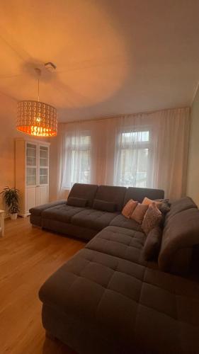 a living room with a couch and a chandelier at NEU! OASIS - FeWo am Harz, hochwertig Kernsaniert, 83 qm, EG in Nordhausen
