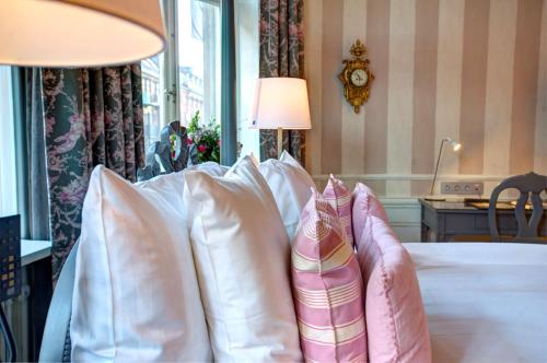 a group of pillows on a bed in a room at Hotel Kung Carl, WorldHotels Crafted in Stockholm