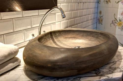 a wooden sink with a faucet in a bathroom at Hotel Kung Carl, WorldHotels Crafted in Stockholm