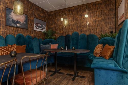 a dining room with blue chairs and tables at Best Western Plus Grand Hotel Elektra in Ludvika
