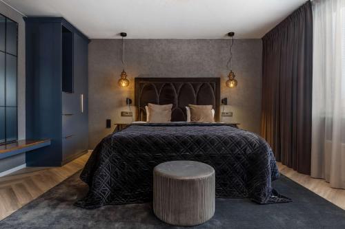 a bedroom with a large bed with a black bedspread at Best Western Plus Grand Hotel Elektra in Ludvika