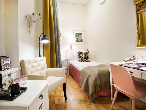 a bedroom with a bed and a desk and a chair at Hotel Kung Carl, WorldHotels Crafted in Stockholm