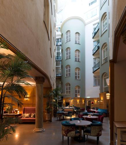 a lobby with tables and chairs and a building at Hotel Kung Carl, WorldHotels Crafted in Stockholm