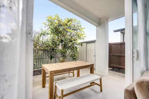 a wooden table and bench in a room with a window at The Solitude - Comfort at its Best by Carmichael Reserve in Tauranga in Tauranga