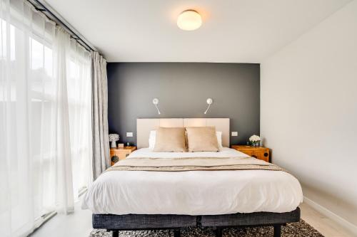 a bedroom with a large bed and a large window at The Solitude - Comfort at its Best by Carmichael Reserve in Tauranga in Tauranga