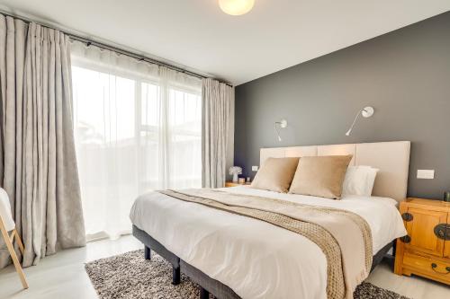 a bedroom with a large bed and a large window at The Solitude - Comfort at its Best by Carmichael Reserve in Tauranga in Tauranga