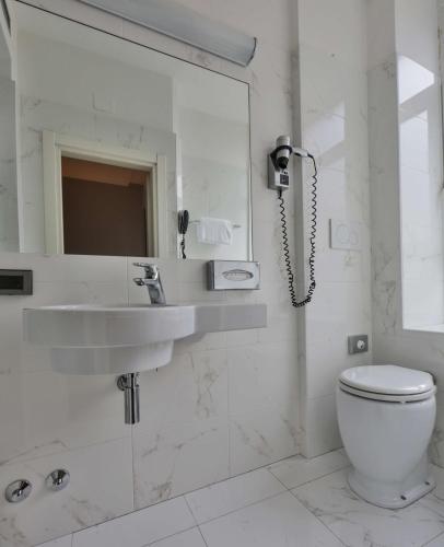a white bathroom with a sink and a toilet at Best Western Madison Hotel in Milan