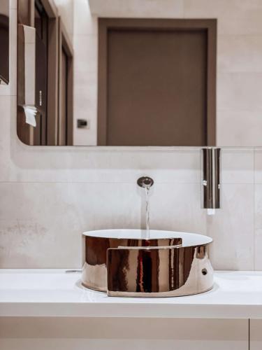 a sink in a bathroom with water pouring into it at Best Western Madison Hotel in Milan