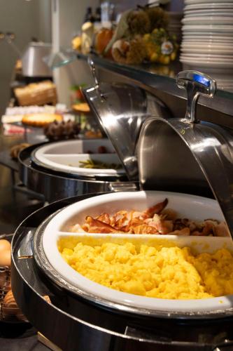 a buffet with plates of food in a restaurant at Best Western Madison Hotel in Milan