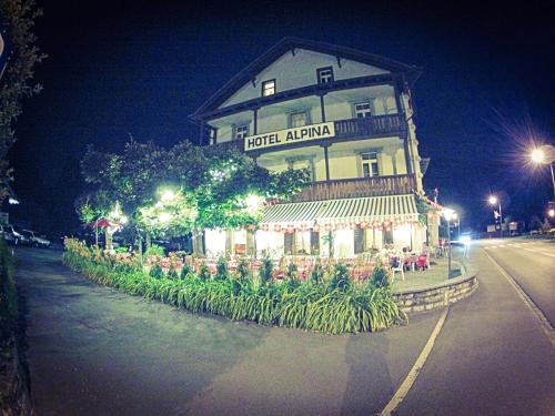 a building on the side of a street at night at Alpina Hotel in Interlaken