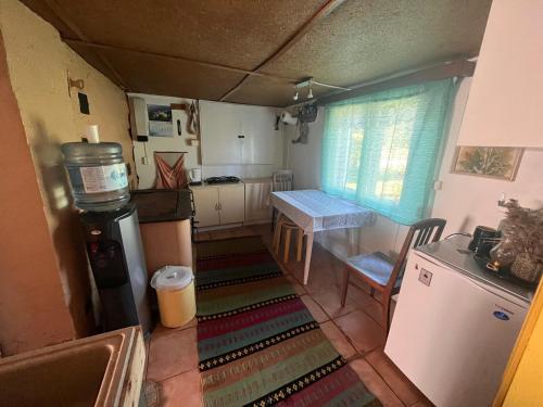 Una pequeña cocina con una mesa y un refrigerador. en Vedru sauna camping, en Väike-Rakke
