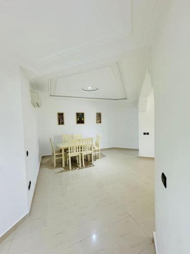 a white room with a table and chairs in it at appartement de vacances achakar plage & piscine & wifi in Tangier