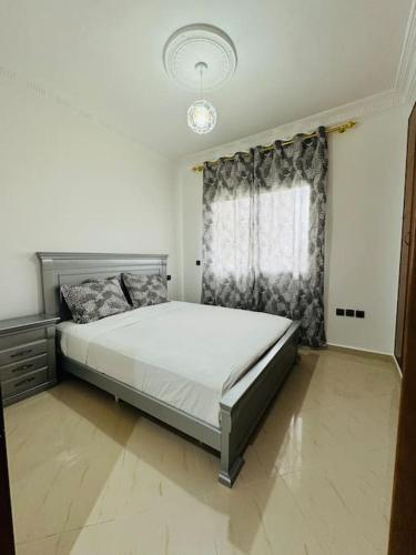a bedroom with a large bed in front of a window at appartement de vacances achakar plage & piscine & wifi in Tangier